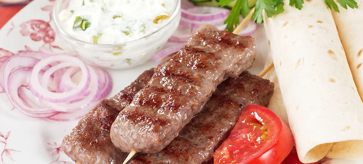 Kebab, minced meat skewer with fresh vegetables and cream sauce