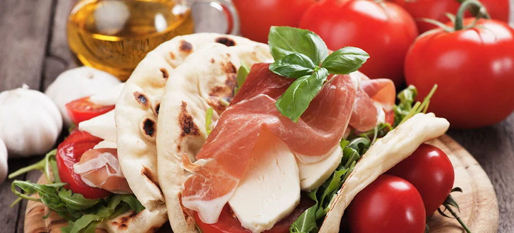 Piadina Romagnola, Italian Flatbread Sandwich with Prosciutto, mozzarella cheese, tomato and rocket salad