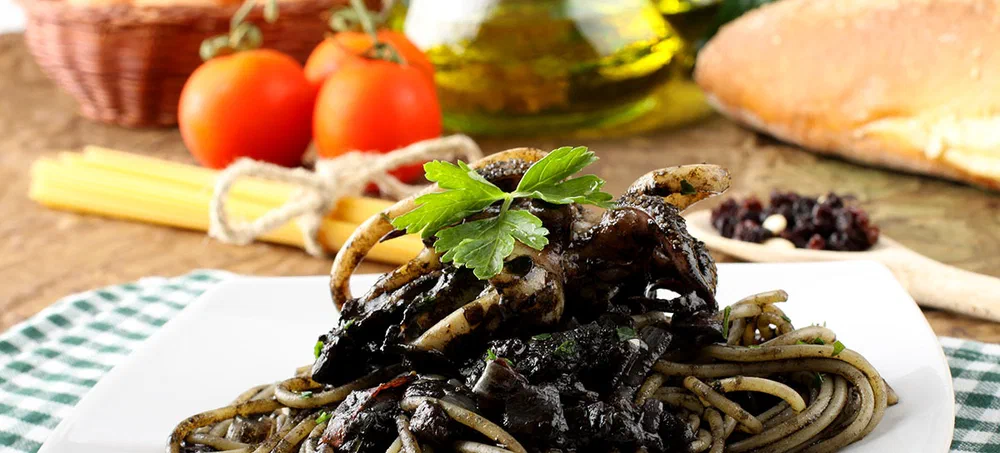 Pasta with squid ink and fresh tomatoes on complex background