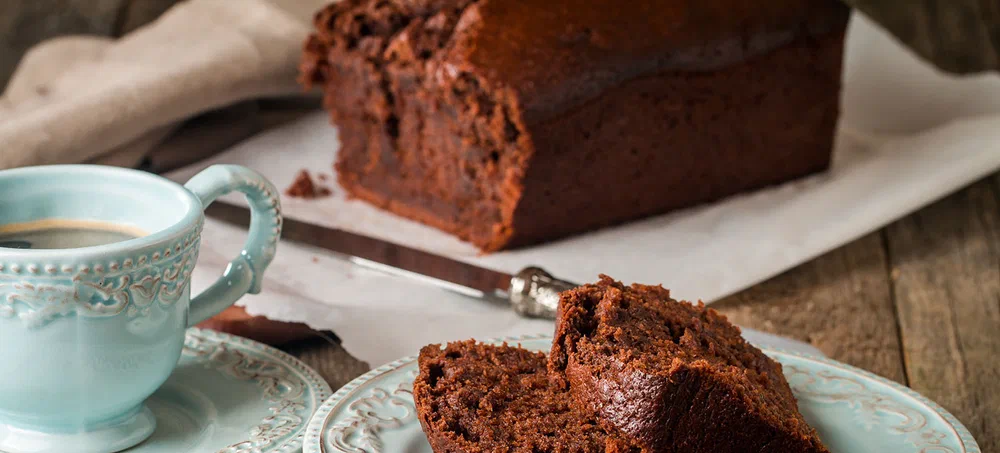 Chocolate-banana Loaf cake on paper  on wooden background